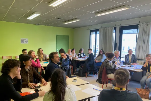Adultes assis dans une salle de classe, durant l'atelier "Comment évaluer des compétences ? Quels indicateurs, notamment à l’ère de l’IA ?"
